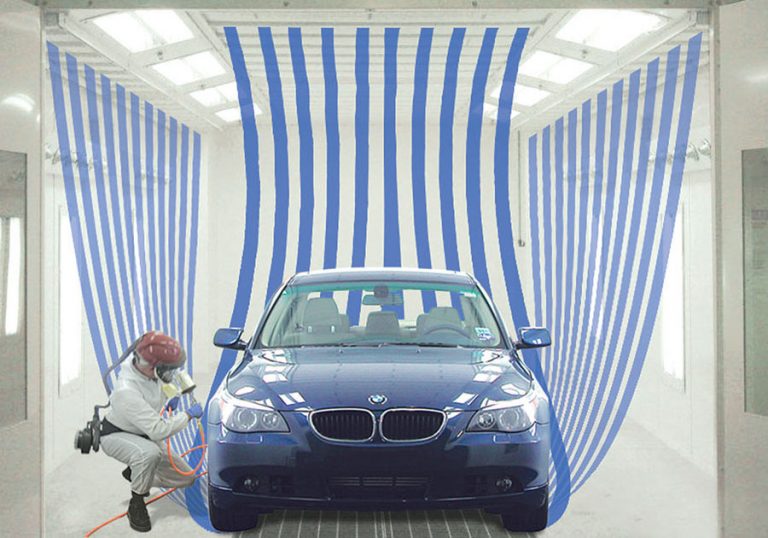 a car being worked on in a GFS Paint Booths by a worker.
